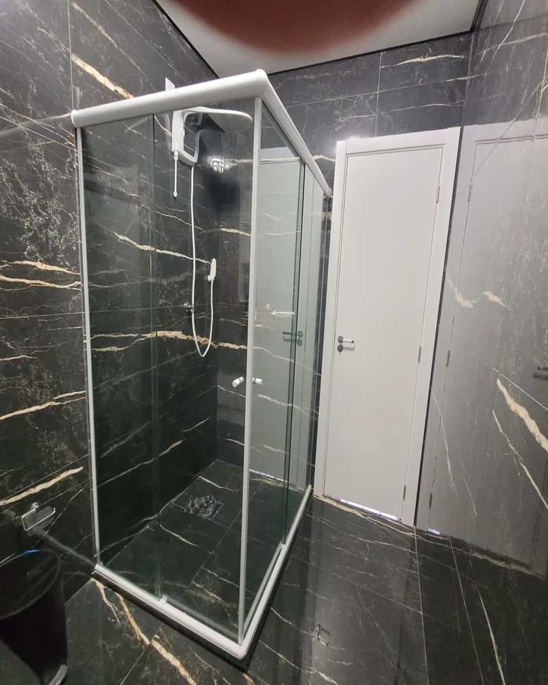 Box de vidro temperado de canto com kit preto em apartamento